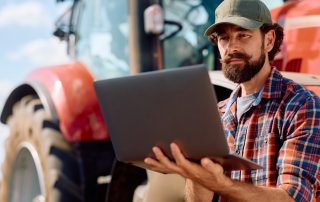 Farmer with a laptop considering his grant applications.
